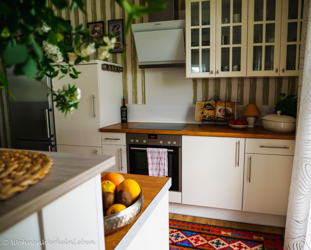 offene Küche weiß gestrichen mit neuen Griffen, Boho Teppich und Arbeitsplatte aus Holz