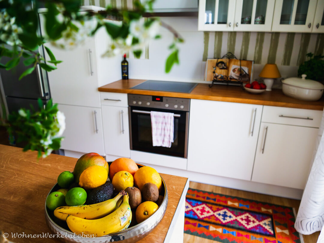 Weiße offene Küche mit Boho Teppich und Obstschale