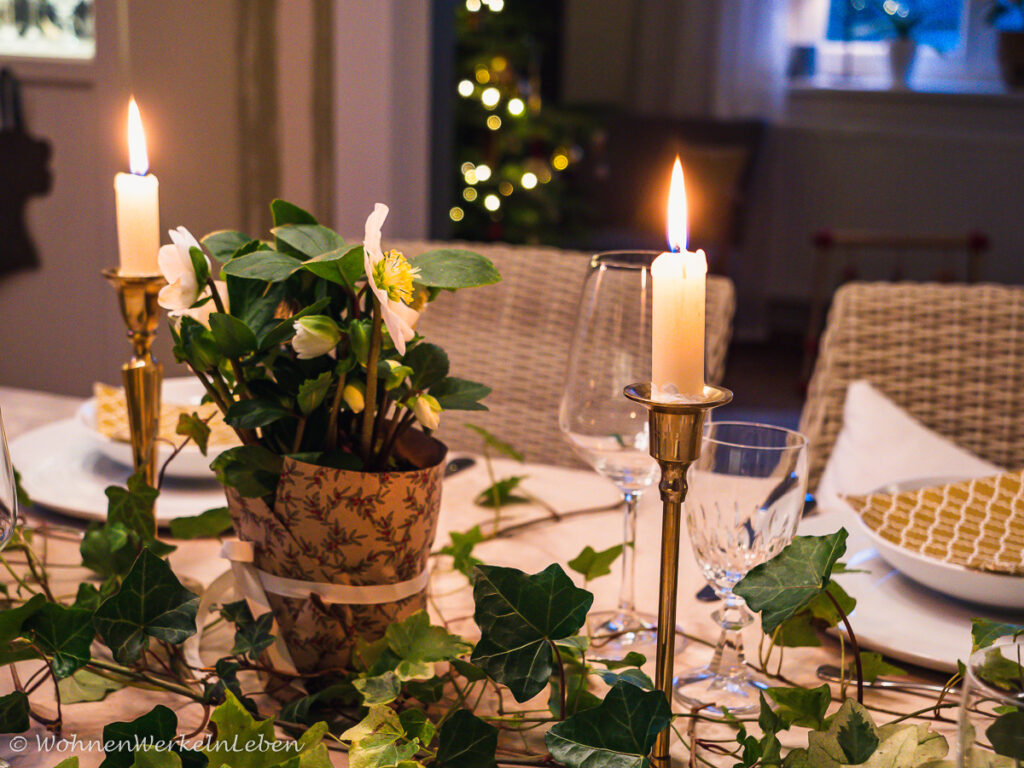 Weihnachtliche Tischdeo mit Efeu, Christrosen und goldenen Kerzen