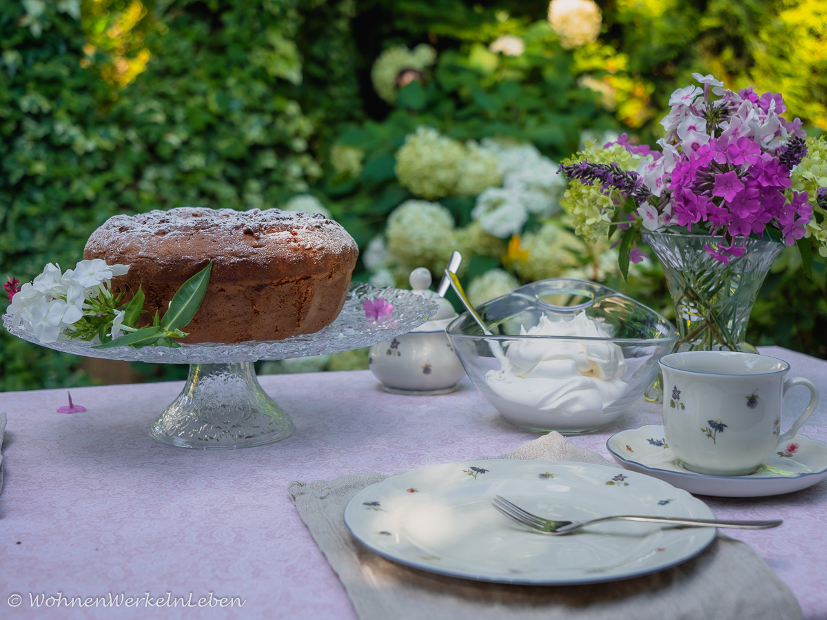 Tischdekoration im Garten mit Blumen in rosa und weiß